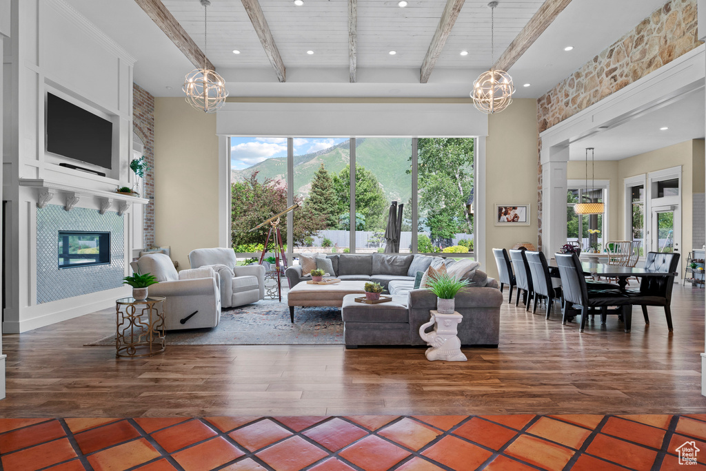 Living area with a chandelier, a large fireplace, wood finished floors, a mountain view, and recessed lighting