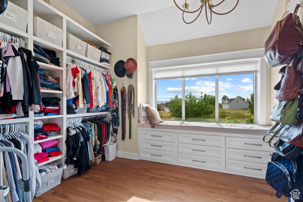 Spacious closet featuring a chandelier and light wood finished floors