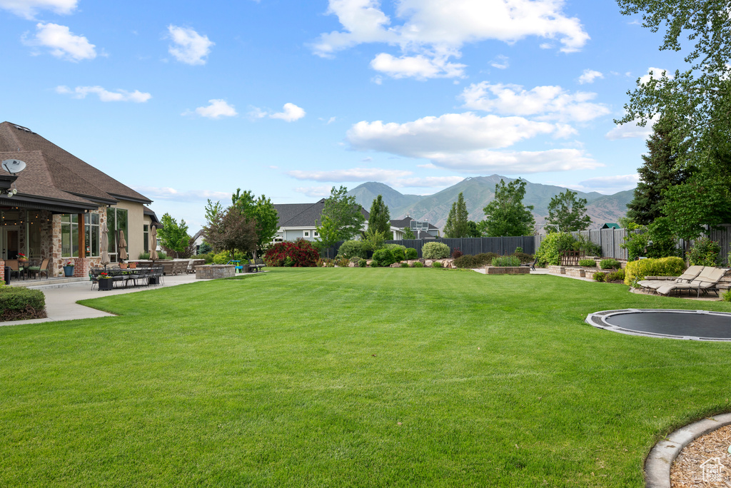 Surrounding community with a mountain view and a patio area