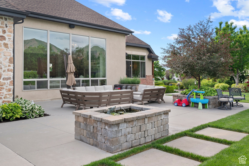 View of patio with an outdoor living space with a fire pit