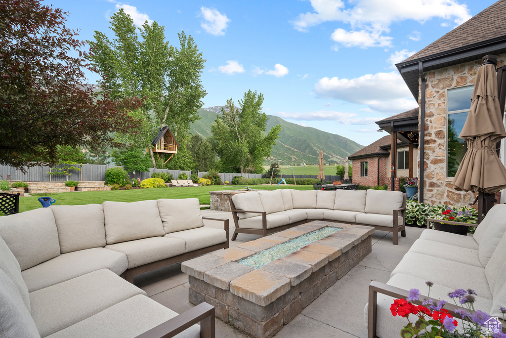 Fenced backyard with a mountain view, outdoor lounge area, and a patio area