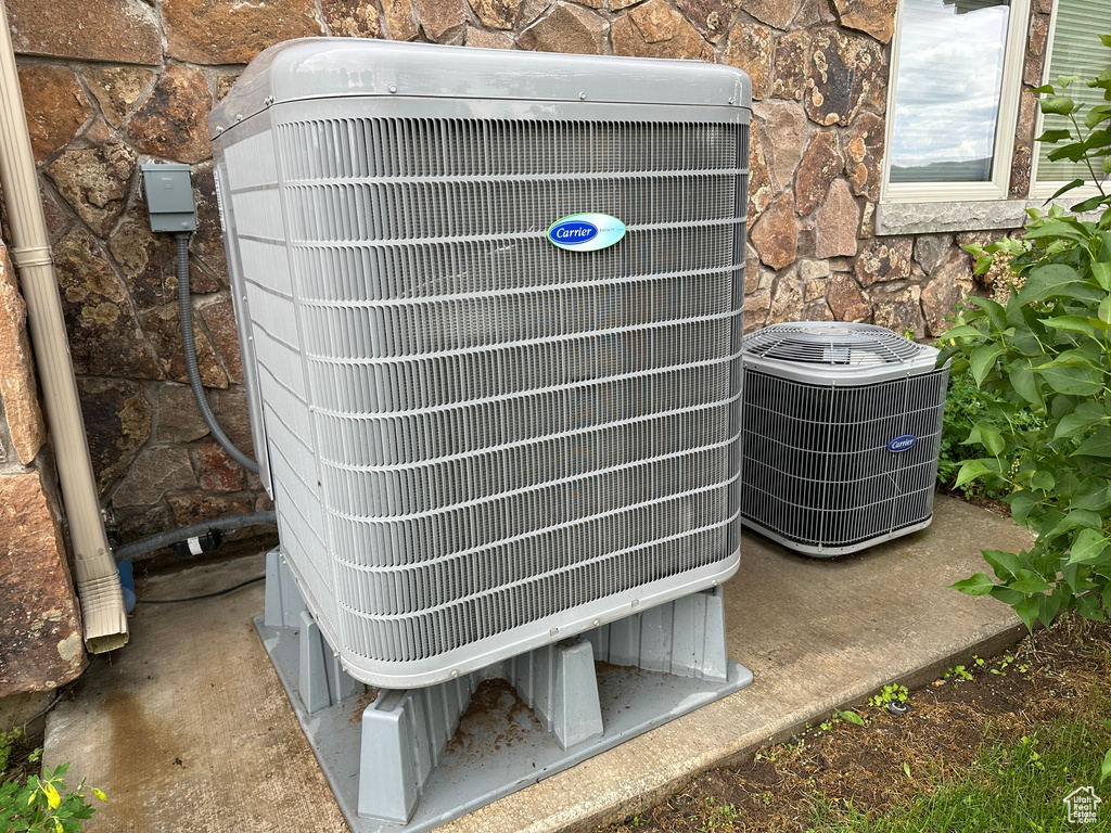 Exterior view of central air condition unit and stone siding