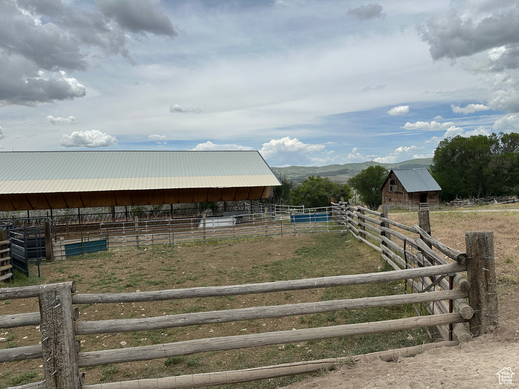 View of yard featuring a rural view, an exterior structure, an outdoor structure, and a mountain view