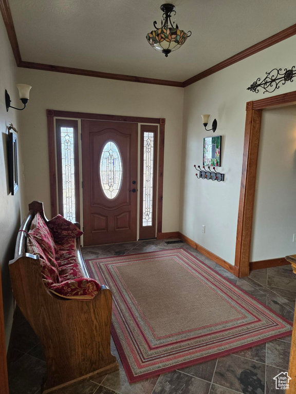 Entrance foyer with baseboards and crown molding