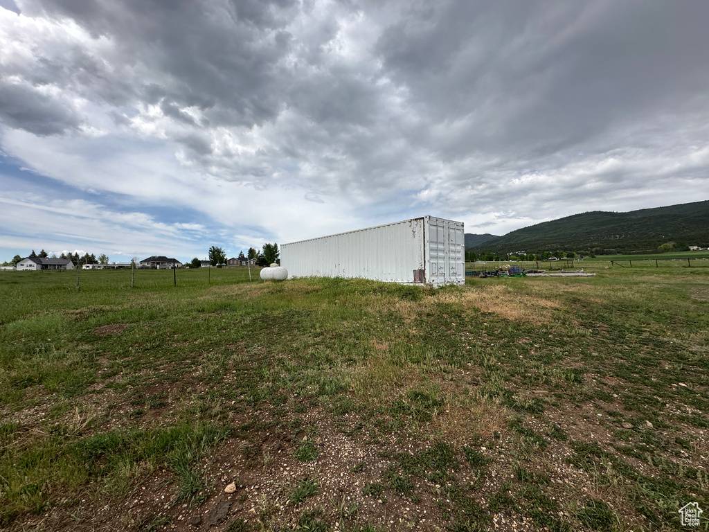 View of yard with a mountain view, a view of rural / pastoral area, and an outbuilding
