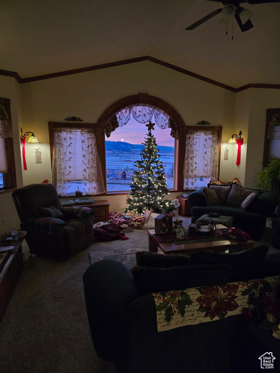 Living area with a ceiling fan, carpet flooring, and lofted ceiling