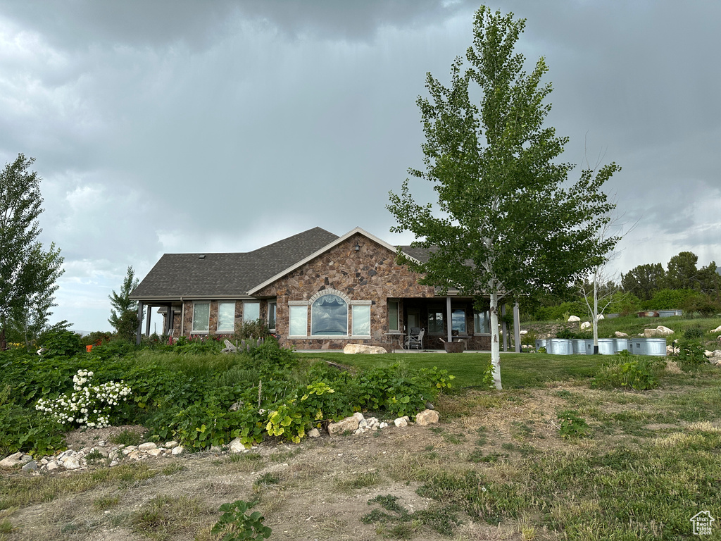 Single story home with stone siding and roof with shingles