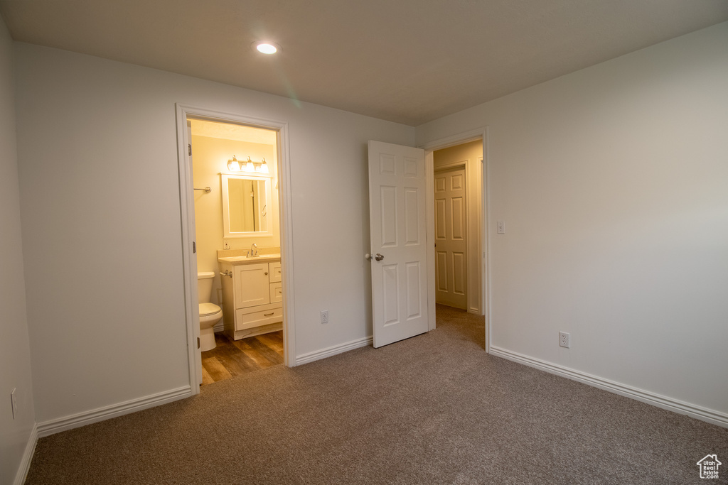 Unfurnished bedroom with carpet flooring, baseboards, recessed lighting, a sink, and ensuite bath