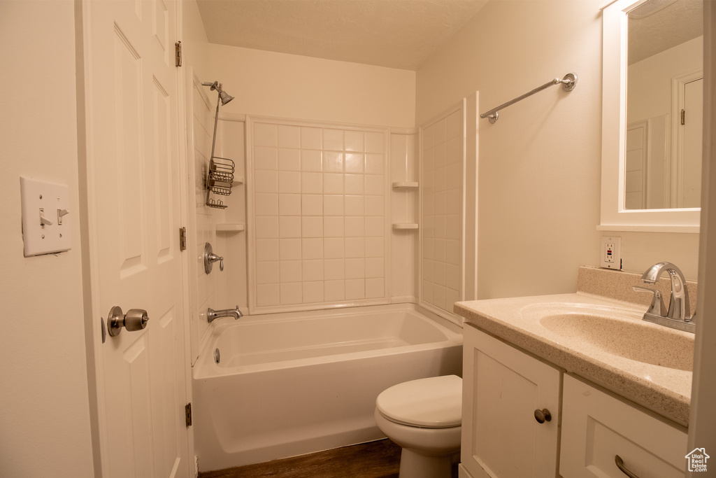 Bathroom with toilet, vanity, bathtub / shower combination, and wood finished floors