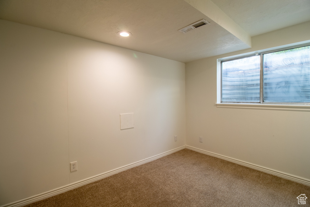 Carpeted spare room featuring baseboards and recessed lighting