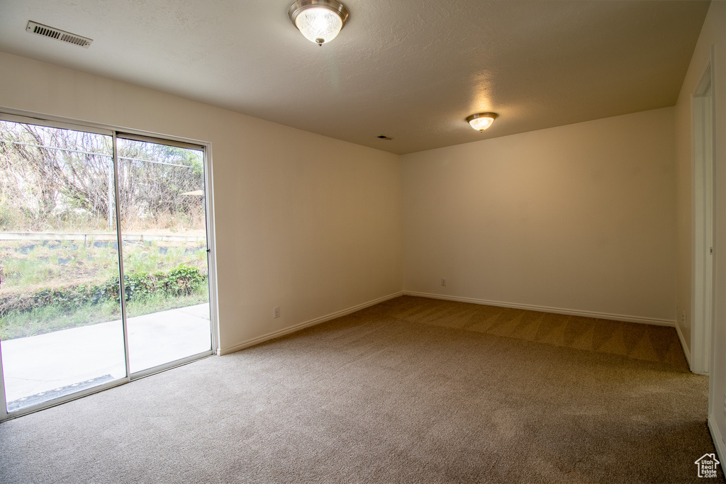 Spare room featuring carpet flooring and baseboards