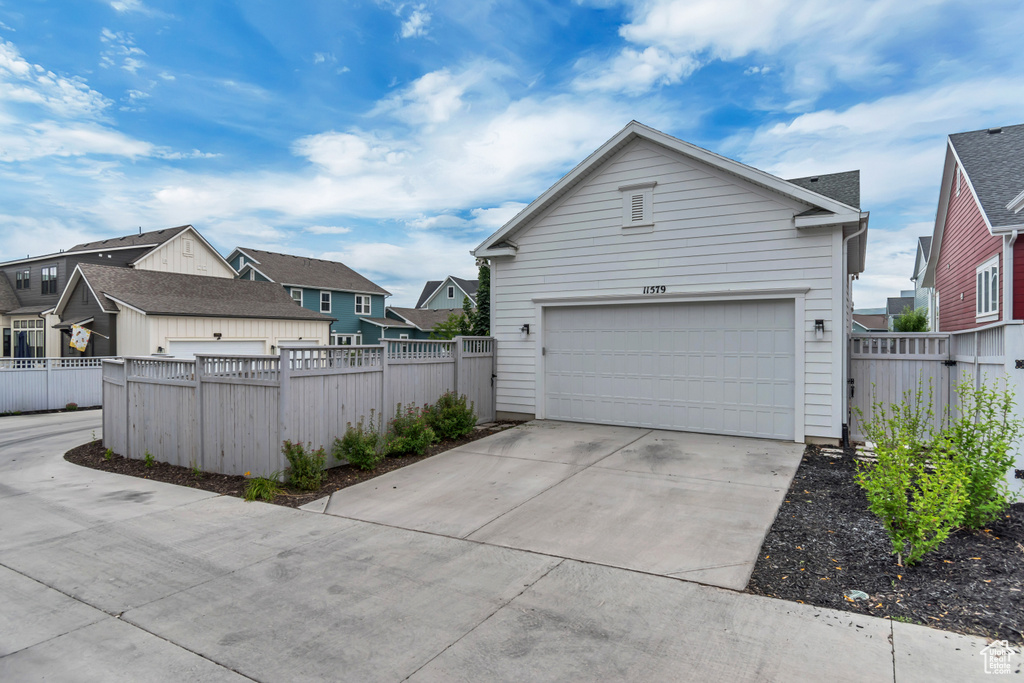 View of side of property featuring a residential view, a garage, and driveway