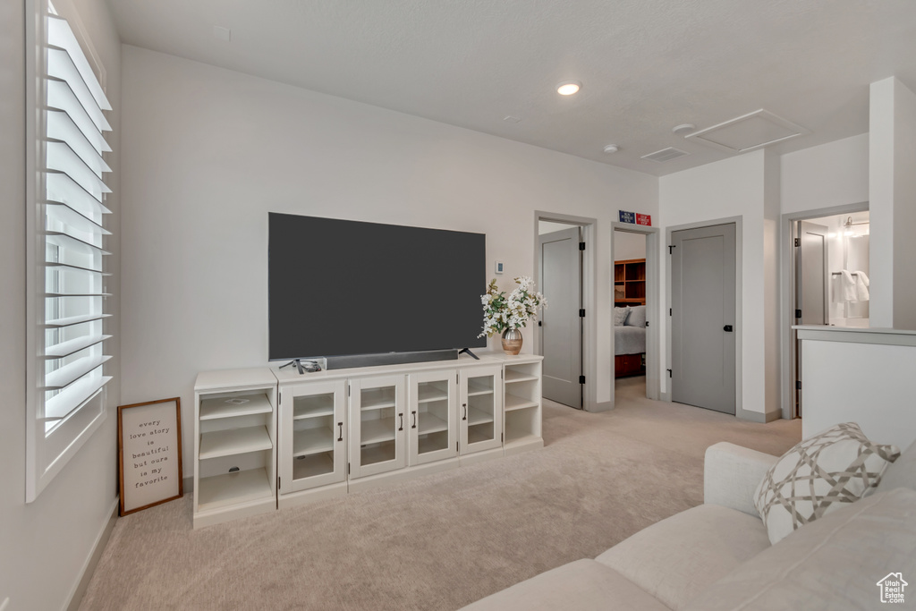 Living area with light carpet, attic access, and recessed lighting