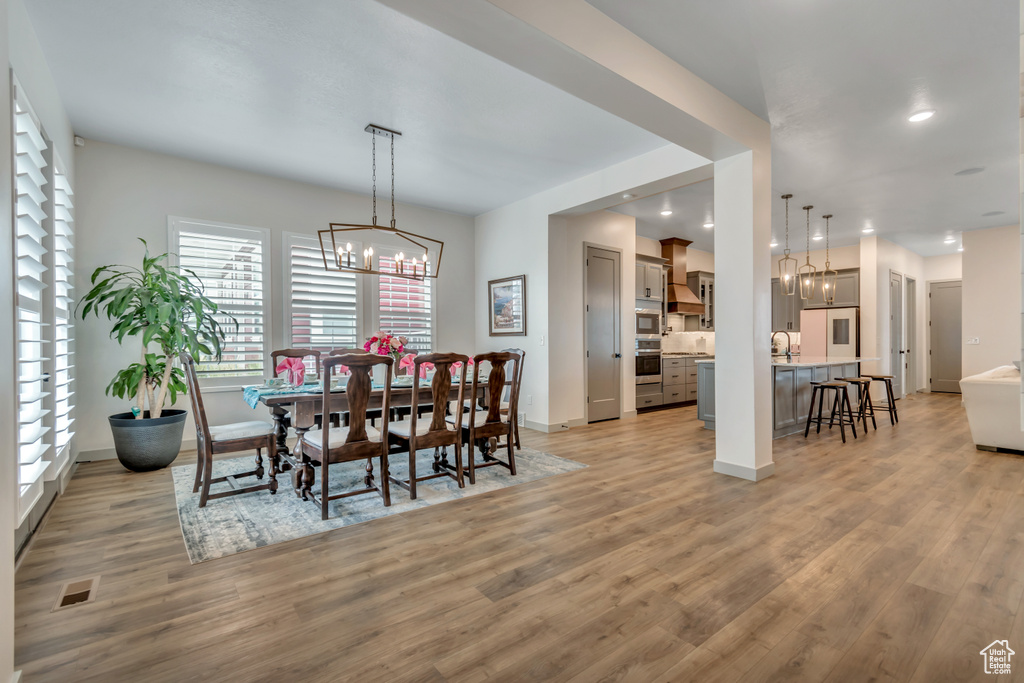 Dining room featuring a chandelier, light wood-type flooring, and recessed lighting