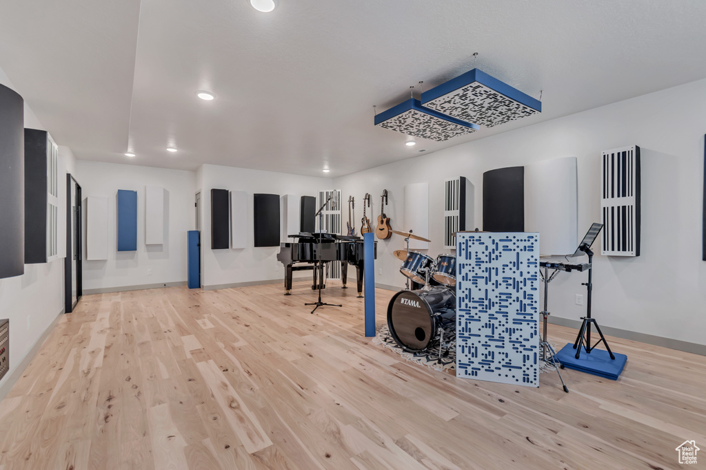 Exercise area with wood finished floors and recessed lighting