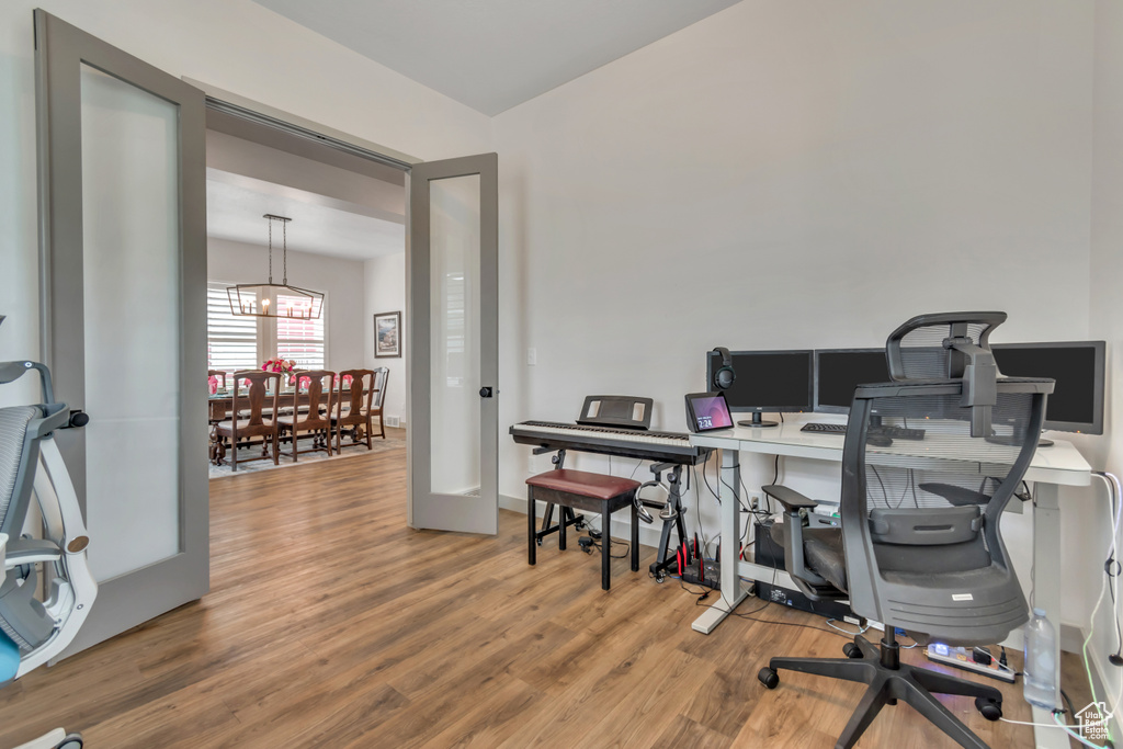 Office space with wood finished floors and a chandelier