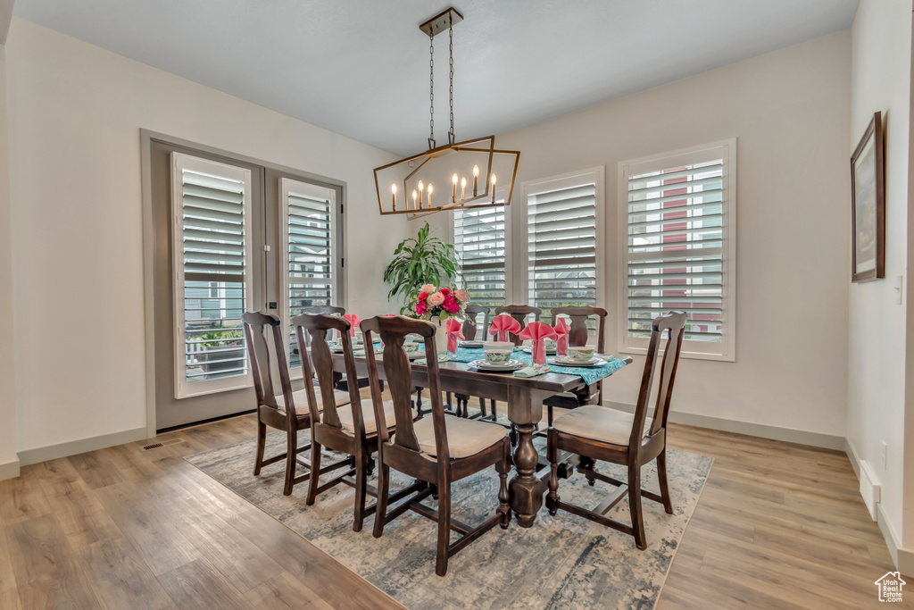 Dining room with plenty of natural light, light wood finished floors, and a chandelier