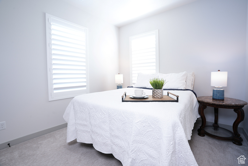 Bedroom featuring carpet and baseboards