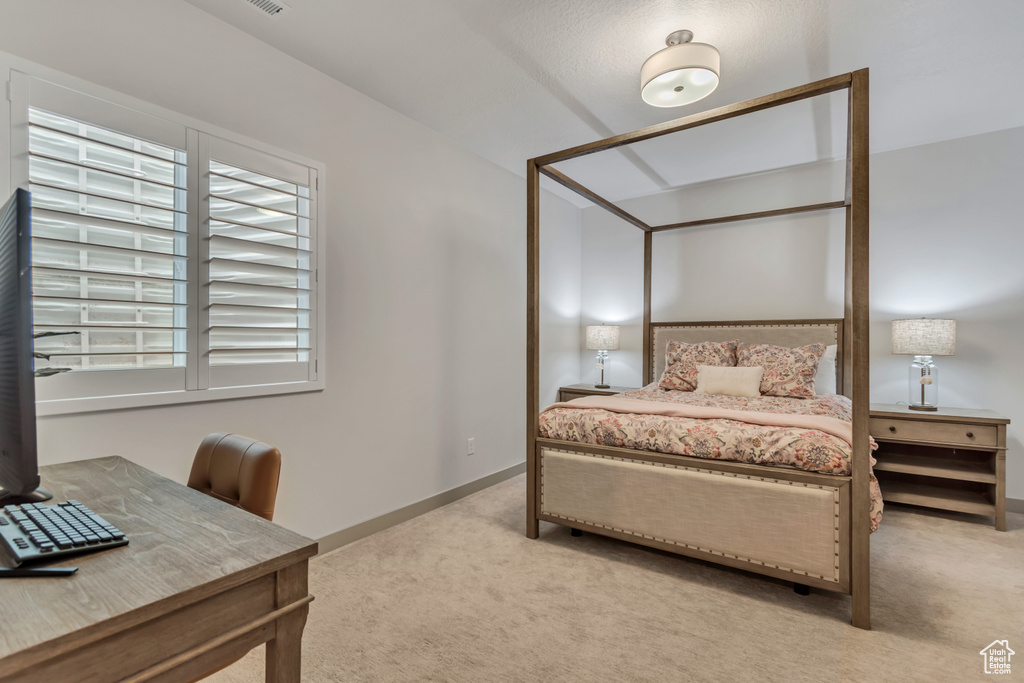 Bedroom with light colored carpet and baseboards