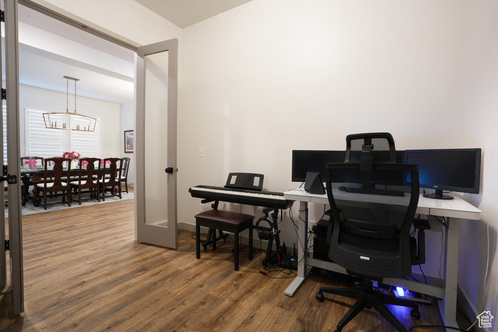 Office with wood finished floors and a chandelier