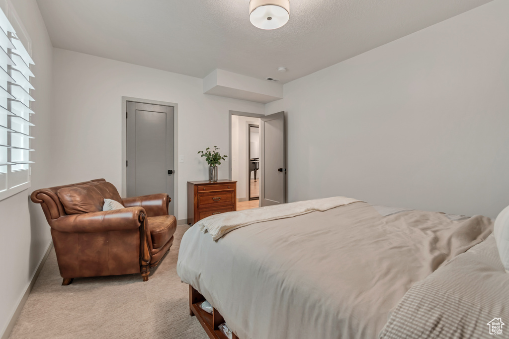 Bedroom with light colored carpet and baseboards
