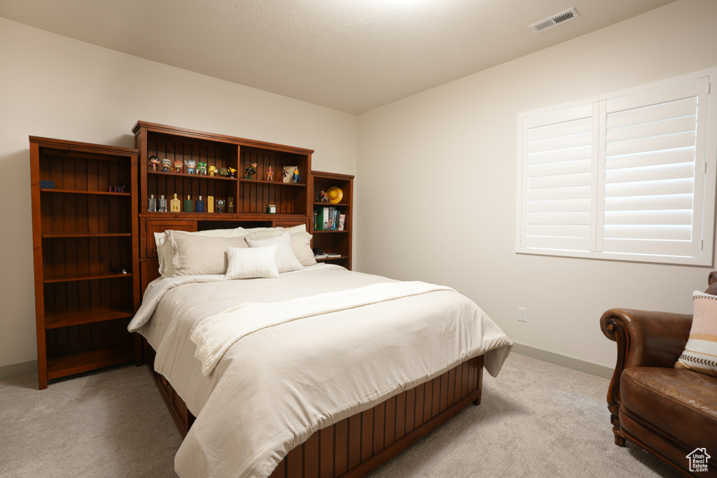 Bedroom with light carpet and baseboards