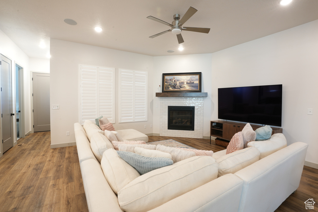Living room featuring ceiling fan, recessed lighting, wood finished floors, and a glass covered fireplace