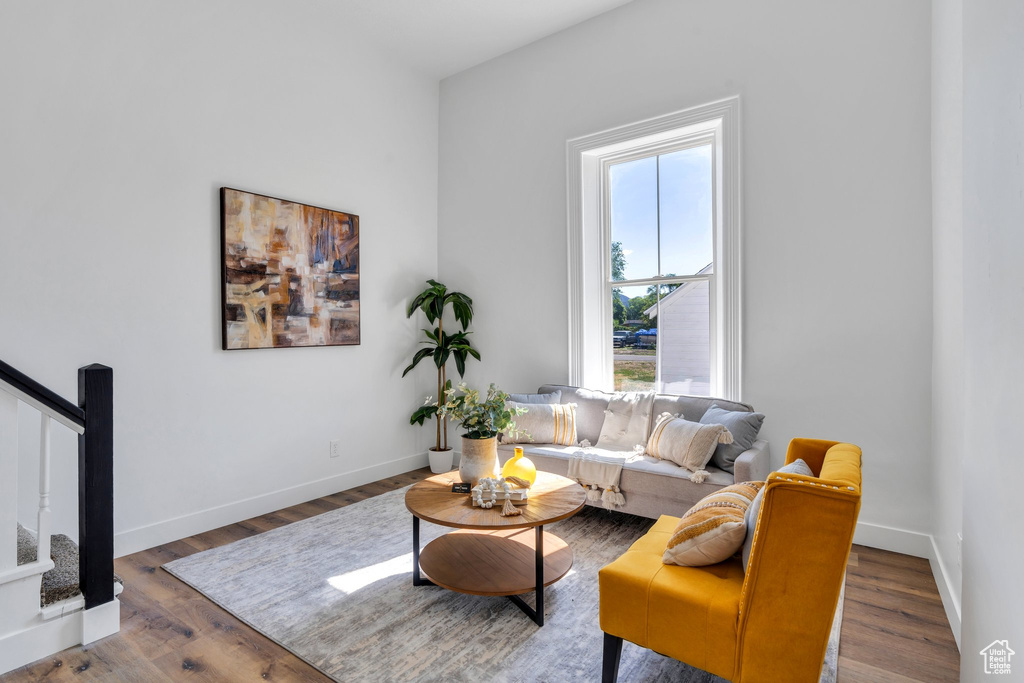 Living room with stairway, wood finished floors, and baseboards
