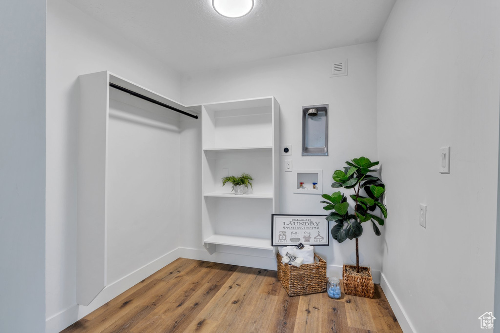 Walk in closet with wood finished floors
