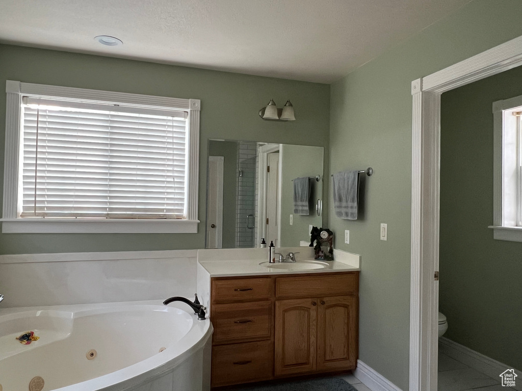 Full bath with vanity, a jetted tub, toilet, baseboards, and a shower stall