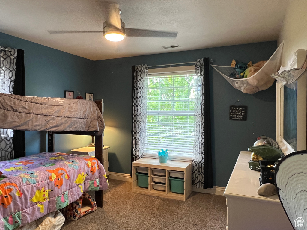 Carpeted bedroom with baseboards and ceiling fan