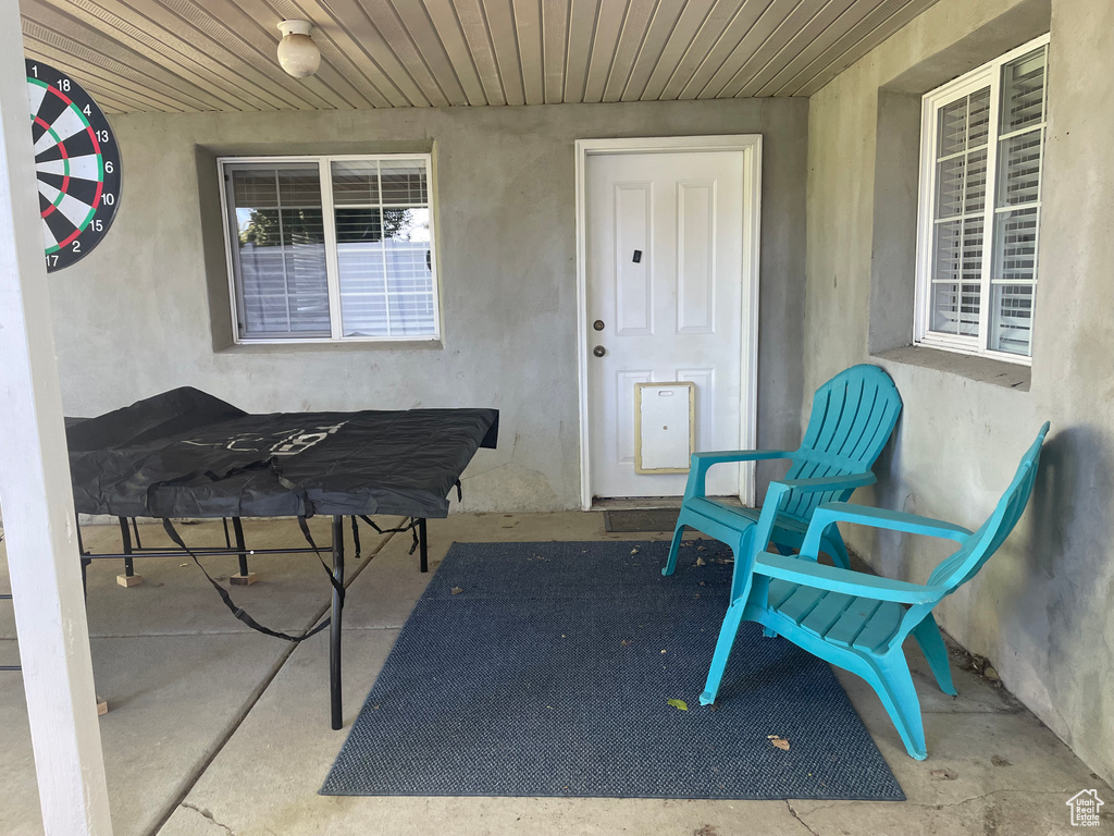 View of exterior entry featuring stucco siding and a patio area
