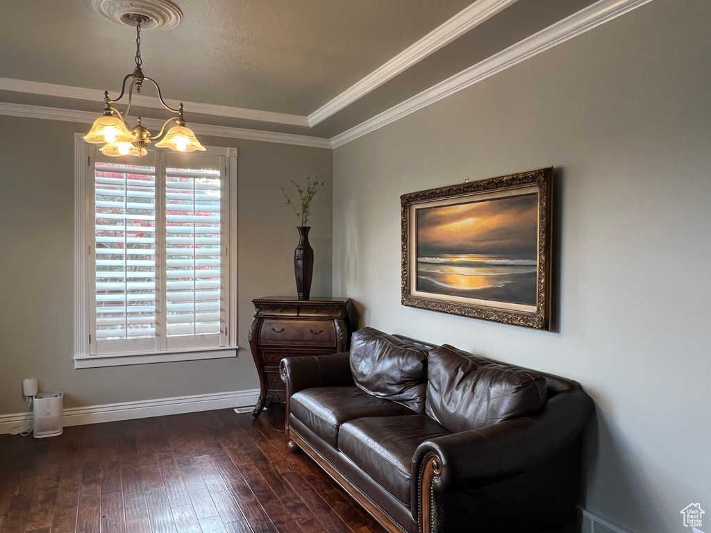 Sitting room with a chandelier, dark wood-style flooring, baseboards, and crown molding