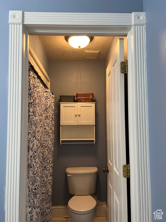 Bathroom featuring toilet and a textured ceiling
