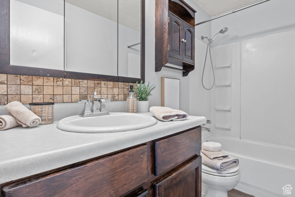 Full bathroom featuring vanity, toilet, tasteful backsplash, and bathing tub / shower combination