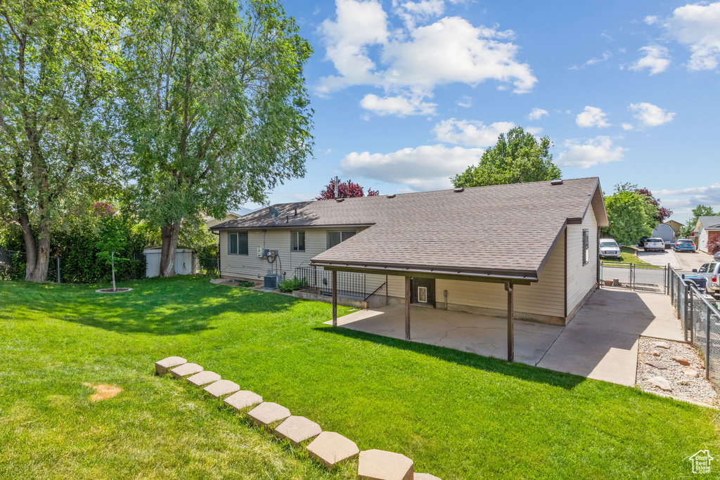 Rear view of house featuring a patio area, a shingled roof, cooling unit, and a gate