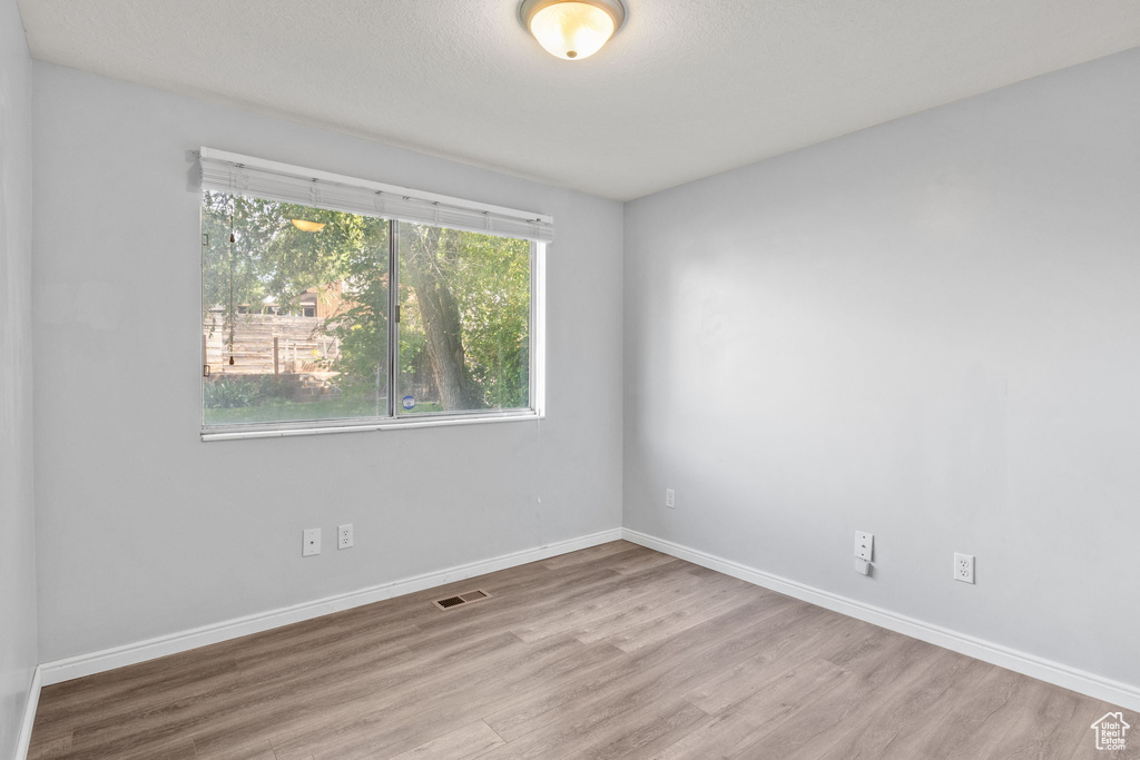 Empty room featuring wood finished floors and baseboards