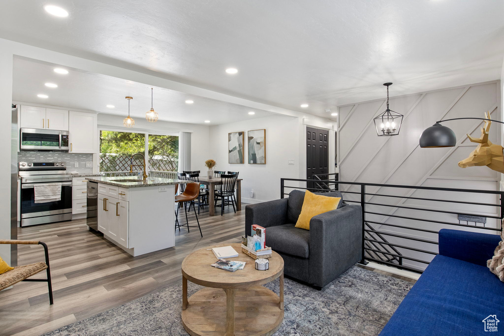 Living area with light wood-style flooring and recessed lighting
