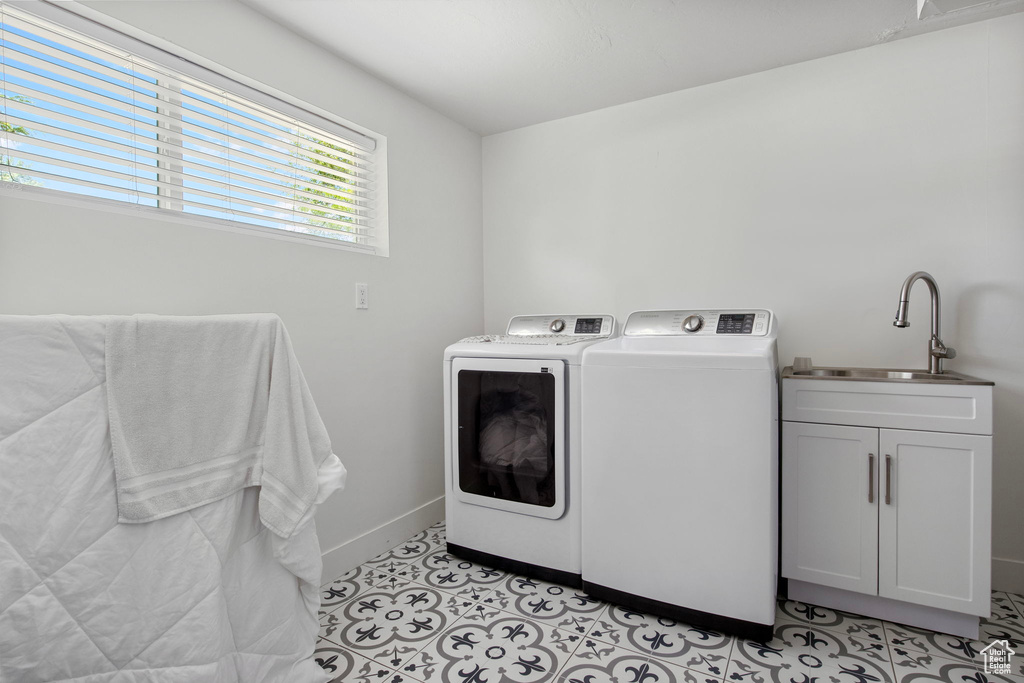 Laundry area with washing machine and dryer, cabinet space, baseboards, and light tile patterned floors