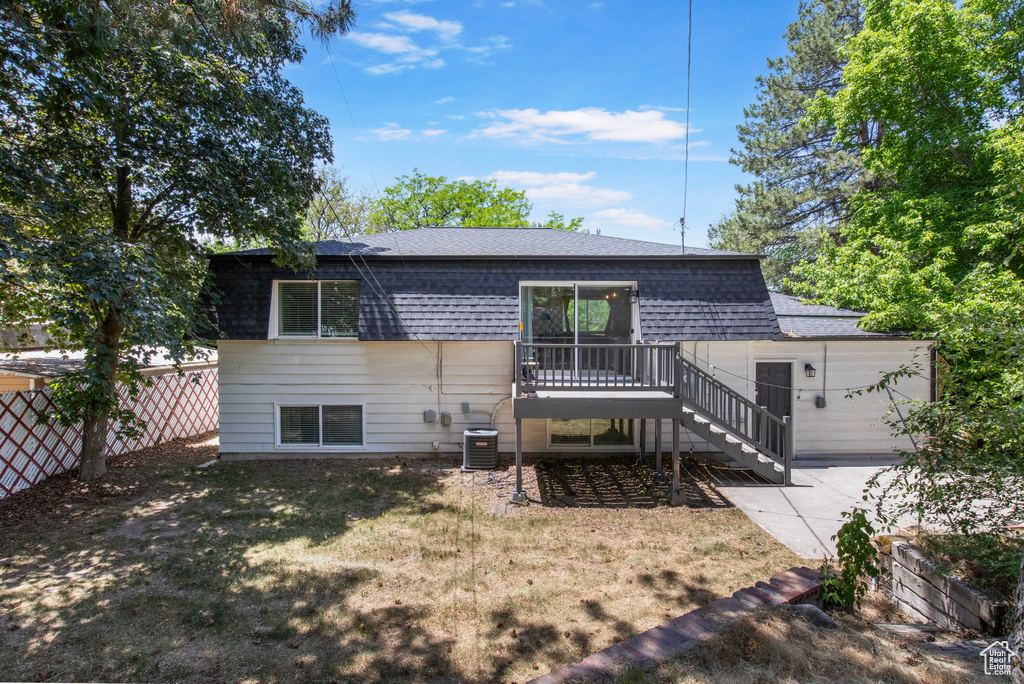 Back of house featuring stairs, a shingled roof, central air condition unit, and a deck