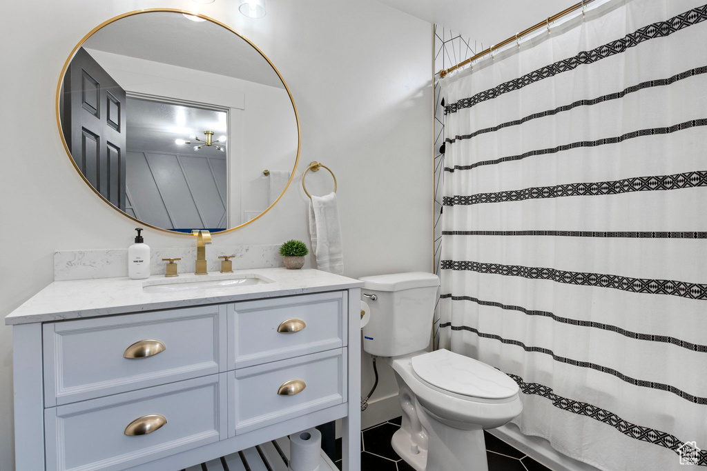 Bathroom featuring toilet, vanity, tile patterned flooring, and a shower with curtain