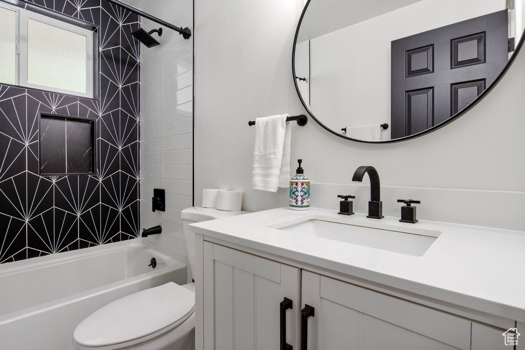 Bathroom with toilet, vanity, and shower / bath combination