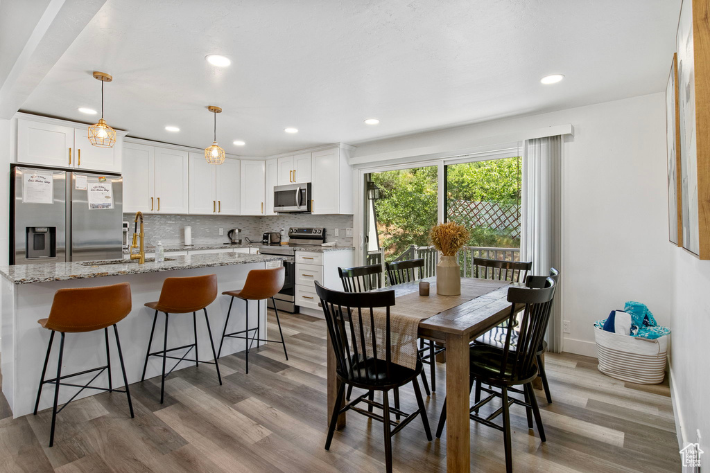 Dining area with light wood-style floors and recessed lighting