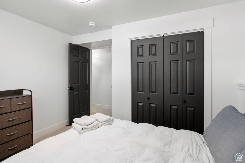 Bedroom with carpet, baseboards, and a closet