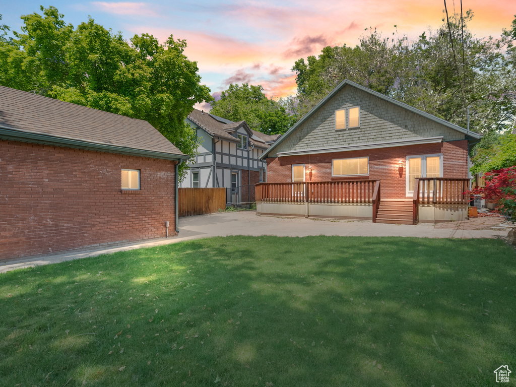 Rear view of property featuring brick siding and a deck
