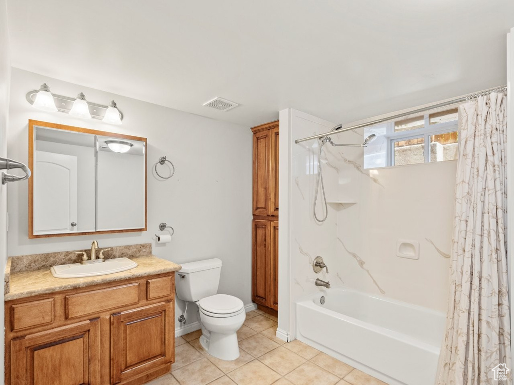Bathroom with shower / tub combo with curtain, toilet, vanity, tile patterned floors, and baseboards