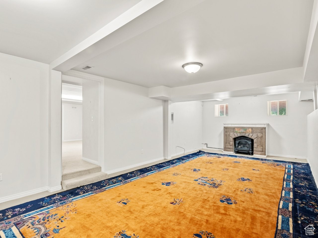Unfurnished living room with baseboards and a stone fireplace