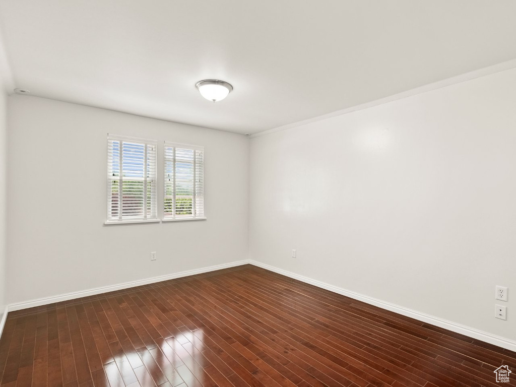 Empty room with baseboards and dark wood finished floors