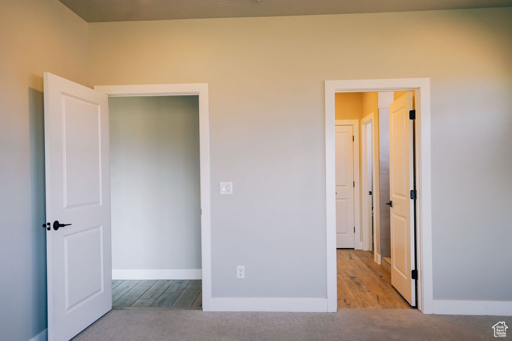 Unfurnished bedroom with wood finished floors and baseboards