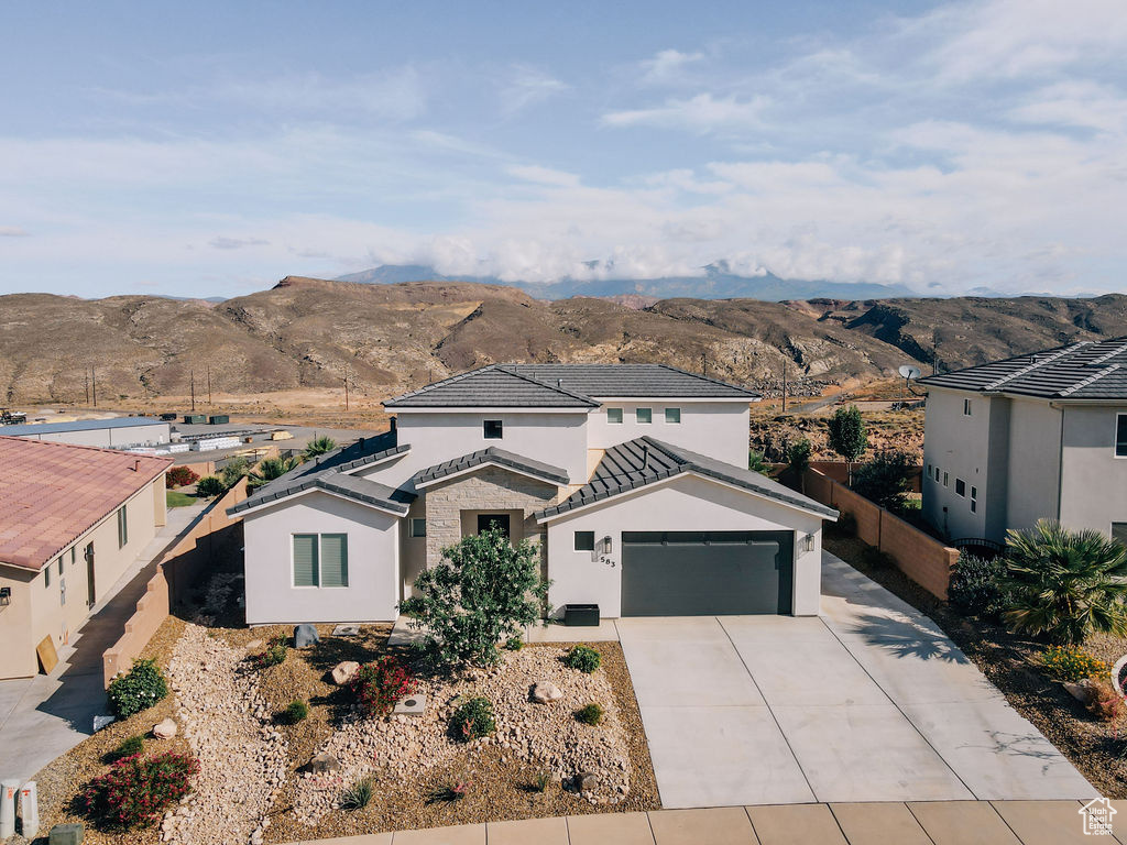 Traditional-style home featuring a mountain view, concrete driveway, stucco siding, and a tiled roof